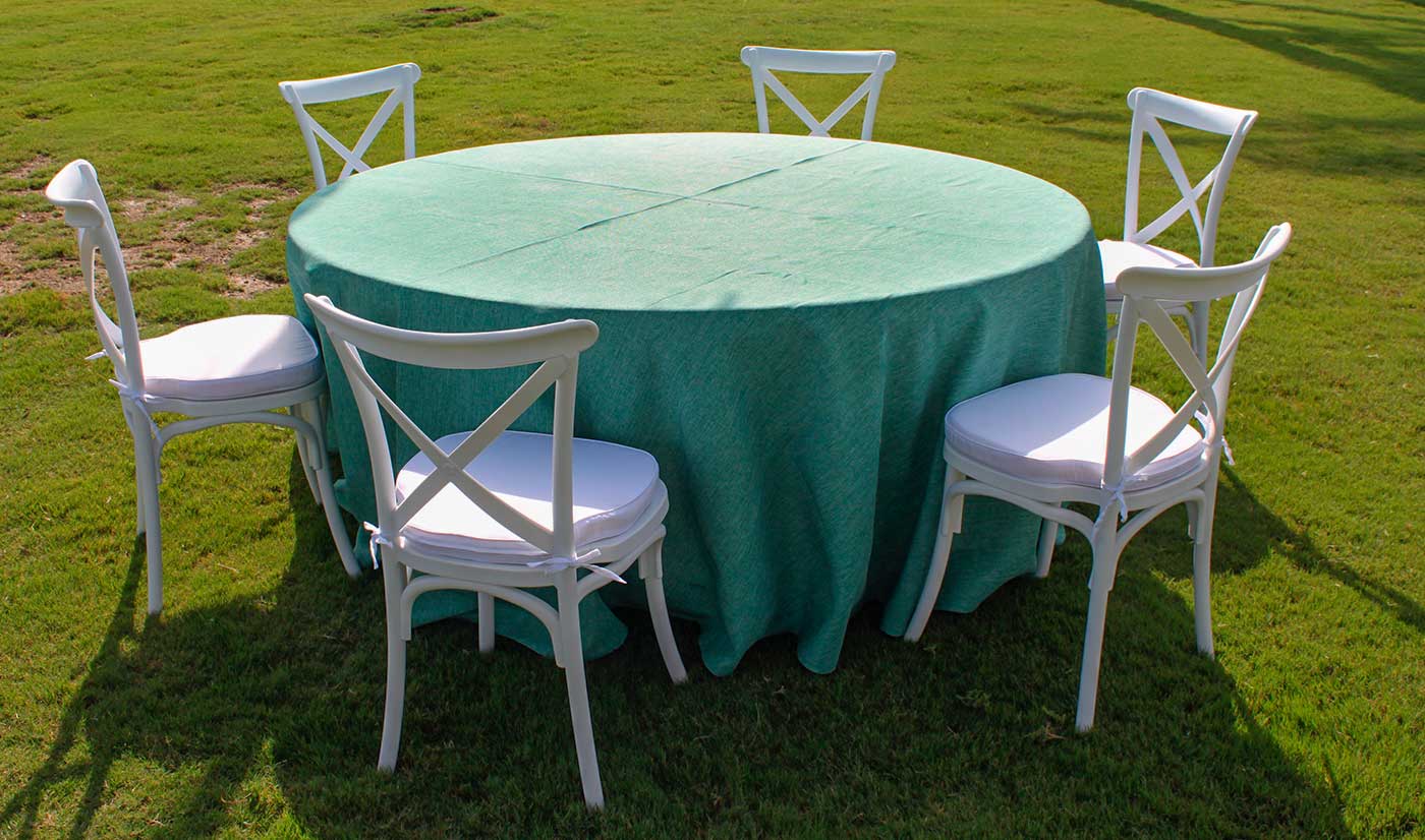 mesa redonda con mantel verde y sillas crossback