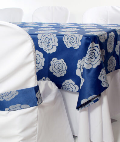 presentación mantel azul con detalles florares y silla con fajin azul con motivos de flores