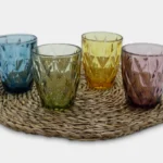 vasos labrados en varios colores sobre puestos en linea sobre decoracion circular para mesa