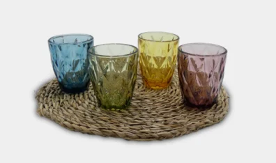 vasos labrados en varios colores sobre puestos en linea sobre decoracion circular para mesa